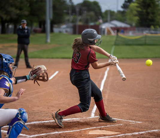 Baseball, Softball Teams Slide into NBL Playoffs Girl hitting softball with catcher behind her
