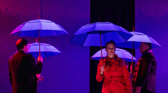 Actors on stage with umbrellas