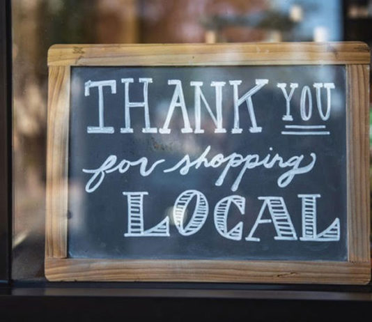 Chalk sign in a shop window thanking people for shopping locally