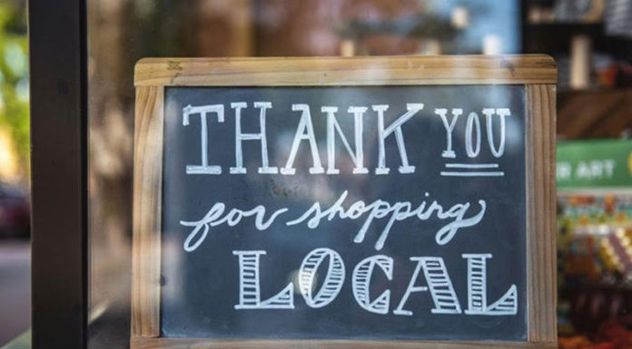Chalk sign in a shop window thanking people for shopping locally
