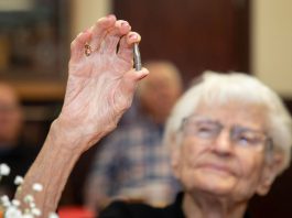 Alice Beck Darrow, 106 years old, holds aloft a silver bullet.
