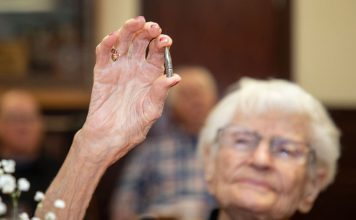 Alice Beck Darrow, 106 years old, holds aloft a silver bullet.
