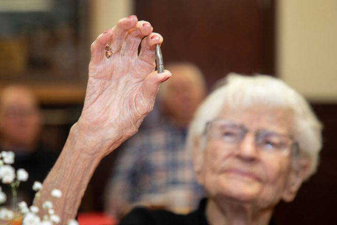 Alice Beck Darrow, 106 years old, holds aloft a silver bullet.