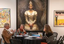 Group discuss art beneath painting