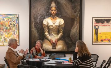 Group discuss art beneath painting