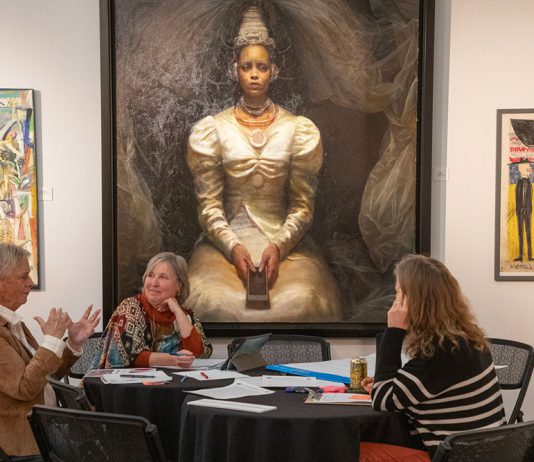 Group discuss art beneath painting