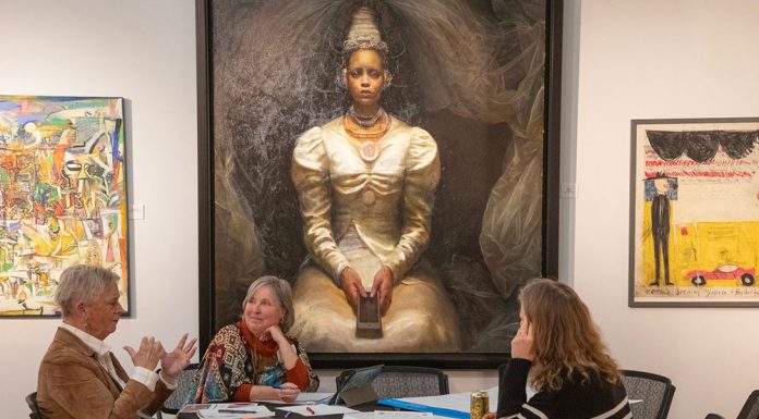 Group discuss art beneath painting