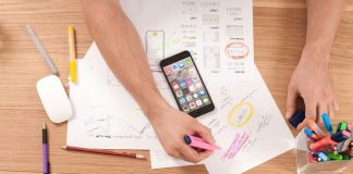 How Review Sites Help Users Make Informed Choices Person reading online reviews on laptop while taking notes at desk