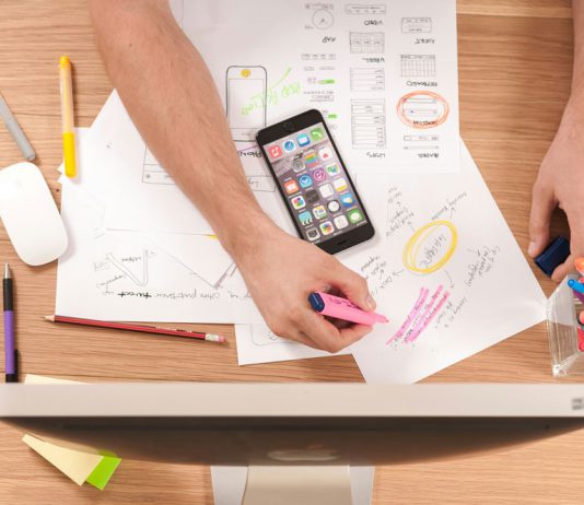 How Review Sites Help Users Make Informed Choices Person reading online reviews on laptop while taking notes at desk